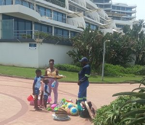 Some visitors are seen buying to the street vendor in Umhlanga beach. Photo Futhi Mbhele, Durban Today