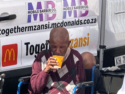 An elderly man refreshes from a McDonald's drink